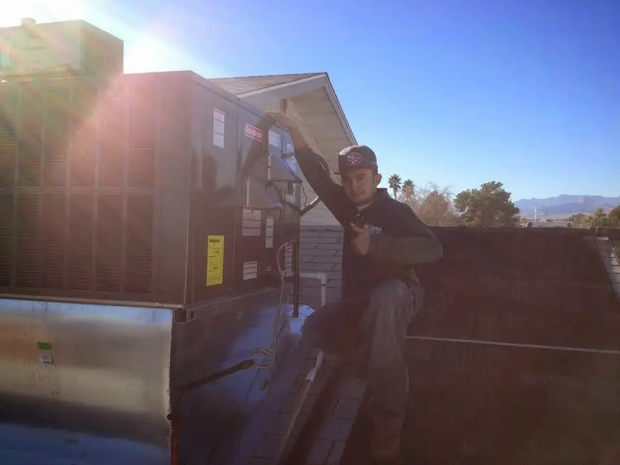 HVAC technician performing HVAC Inspection on a rooftop unit in Milford